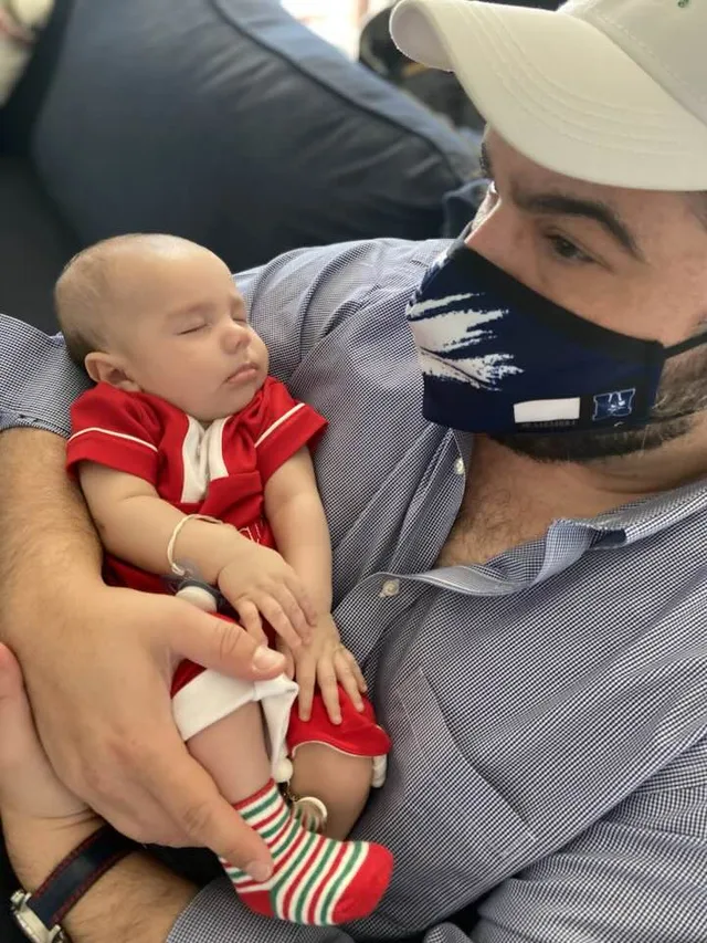 Eddie Gonzalez Loumiet holding a baby at a family gathering