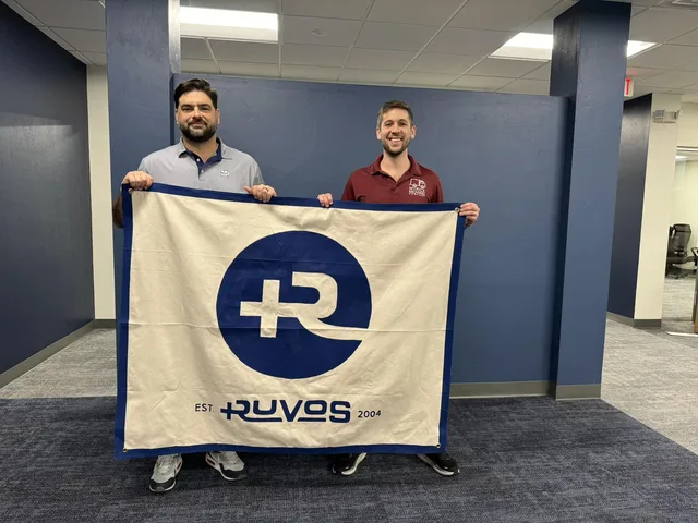Eddie Gonzalez Loumiet displaying the Ruvos company flag at a team event